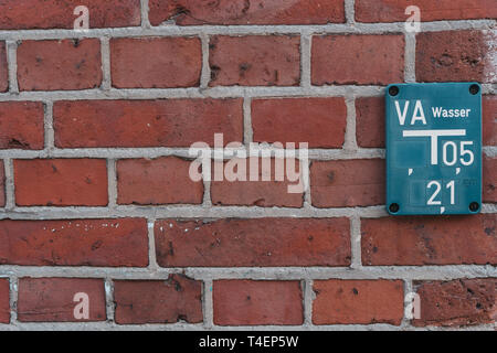 Tableau d'incendie bleu sur mur de brique rouge Banque D'Images