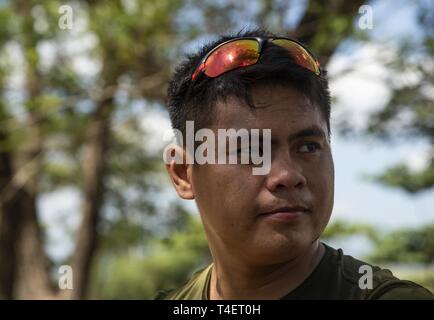 L'Aviateur de l'Armée de l'Air Philippine 2e classe Jomel Adona prend une pause pendant un défenseur pacifique des forces de sécurité l'échange d'experts en la matière à Cesar Basa Air Base, Philippines, le 4 avril 2019, dans le cadre de l'exercice Balikatan. L'exercice aide à maintenir un haut niveau de préparation et de réactivité, et il améliore l'ensemble des relations et des capacités militaires. Adona est originaire de Candijay, Bohol, Philippines, et un agent de sécurité affecté à la base de la masse 554th Groupe Défense aérienne. Banque D'Images