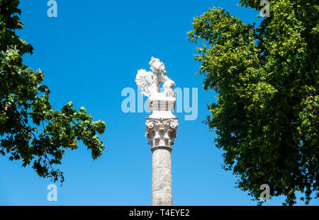 La statue d'un lion surréaliste avec une queue cassée assis sur une colonne romaine à l'extrémité nord de la Alameda à Séville Banque D'Images