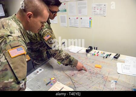 Texas Army National Guard Le Capitaine James Dorman, officier des opérations, discute de l'ordre d'opération avec le 1er bataillon, le Lieutenant Jeff Dahl, siège de l'Administration centrale et compagnie, 7 avril 2019, date à Gowen Field. La formation fournie le bataillon l'occasion d'effectuer une simulation d'une violation par un bataillon ennemi obstacle courroie à l'aide de son M1A2 Abrams char de combat principal, véhicules de combat Bradley et HMMWVs. En utilisant les simulateurs maximisé le temps de formation et permet à l'unité de la pratique de commandement de mission dans un environnement contrôlé. Banque D'Images