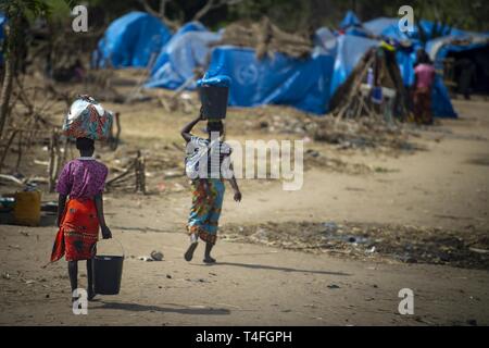 Deux femmes porter la nourriture sur leur tête dans un village près de Chimoio, Mozambique, 9 avril 2019. Combined Joint Task Force-Horn of Africa est à la tête du Département de la défense des efforts de secours en Idai Cyclone au Mozambique à l'appui de l'Agence des États-Unis pour le développement international (USAID) Équipe d'intervention en cas de catastrophe. Le groupe de travail contribue à répondre aux besoins identifiés par les équipes d'évaluation de l'USAID et des organisations humanitaires travaillant dans la région en fournissant un soutien logistique et de la main-d'oeuvre de l'USAID à la demande du Gouvernement de la République du Mozambique. Banque D'Images