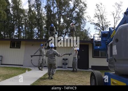 Les aviateurs de la 103e Escadron de génie civil déposer des panneaux solaires à partir d'une cabine à l'Air Force Station, soufflets, Hawaii Kailua, 9 avril 2019. Aviateurs du 103e sont de plus en plus ces compétences au cours de leur préparation à l'essentiel pour le déploiement de la formation. Banque D'Images