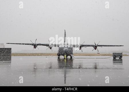 Un 36e Escadron de transport aérien C-130J Super Hercules est assis sur la piste pendant une tempête de neige de fin de saison le 10 avril 2019 à Yokota Air Base, le Japon. Par la pluie, grésil, grêle, ou la neige, les membres de l'équipe de Yokota de respecter les mission. Banque D'Images