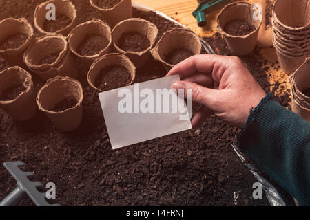 Gardener holding blank business card mock up au-dessus de l'agriculture biologique et de l'équipement de jardinage Banque D'Images