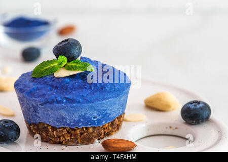 Blueberry et de pois cajou cake vegan papillon avec les baies fraîches, menthe, noix. La nourriture végétalienne saine concept. close up Banque D'Images