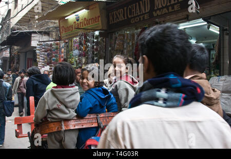 Les enfants sont pris à la maison après l'école dans un pousse-pousse. Delhi, Inde Banque D'Images