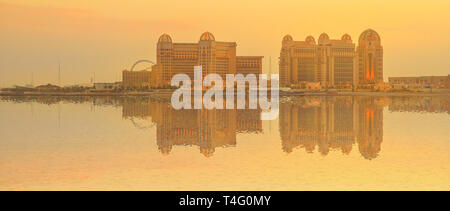 Paysage urbain de bannière luxury resort hotel de West Bay réfléchissant sur la baie de Doha, au crépuscule de Porto Saoudite, le port principal de Pearl-Qatar à Doha Banque D'Images