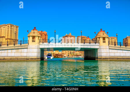 Entrée privée et pont de Porto Saoudite Marina au Pearl-Qatar, Doha dans le golfe Persique, au Moyen-Orient de bateau-taxi. Journée ensoleillée, ciel bleu. Copier l'espace. Banque D'Images