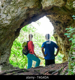 Les randonneurs d'admirer une impressionnante grotte en forêt Banque D'Images