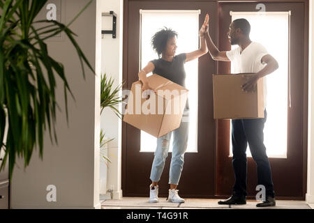 Heureux couple élevé donnant cinq, célébrer la réinstallation Banque D'Images