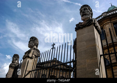 Une rangée de têtes sculptées en pierre montée sur le parapet et embarquement à l'Sheldonian Theatre dans Broad Street, Oxford, Angleterre. On ne sait pas qui le Banque D'Images