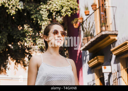 Portrait d'une Amérique fille ou femme hispanique portant des lunettes de soleil dans une ville coloniale au Mexique l'été Banque D'Images