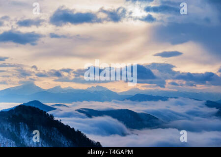 De belles montagnes et distant winter avec brouillard skyscape Banque D'Images