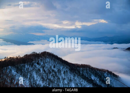 De belles montagnes et distant winter avec brouillard skyscape Banque D'Images