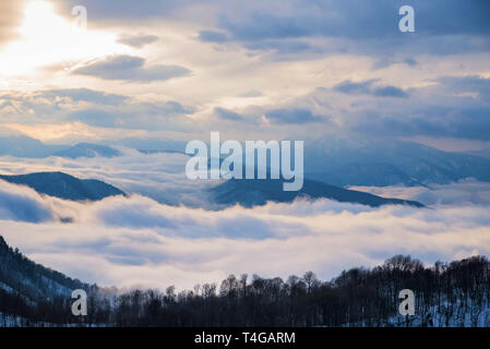 De belles montagnes et distant winter avec brouillard skyscape Banque D'Images