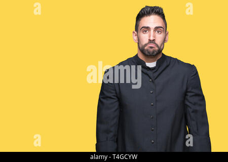 Jeune prêtre chrétien sur fond isolé déprimé et d'inquiétude pour la détresse, pleurant en colère et peur. Expression triste. Banque D'Images