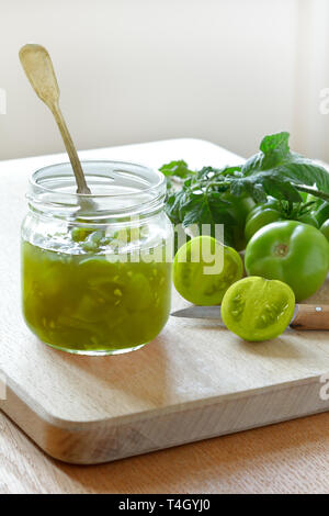 Confiture de tomate verte ou savourer dans un bocal en verre avec une cuillère, vintage accueil concept mise en conserve Banque D'Images