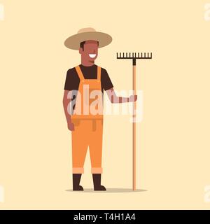 Holding rake jardinier african american man pays travaillant dans l'agriculture jardinage jardin concept eco pleine longueur Illustration de Vecteur