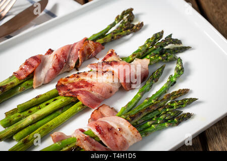 Plaque avec bacon enveloppé d'asperges et quelques épices Banque D'Images