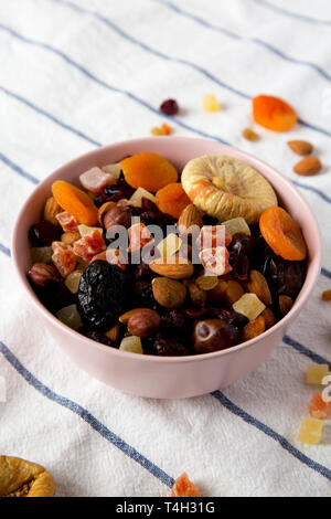 Les fruits séchés et les noix dans un bol rose, low angle view. Close-up. Banque D'Images