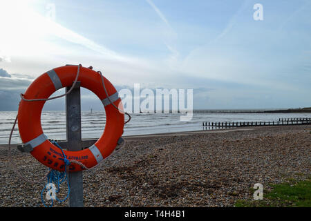 Sauver la vie d'Orange anneau attaché à un post sur front de Littlehampton Banque D'Images