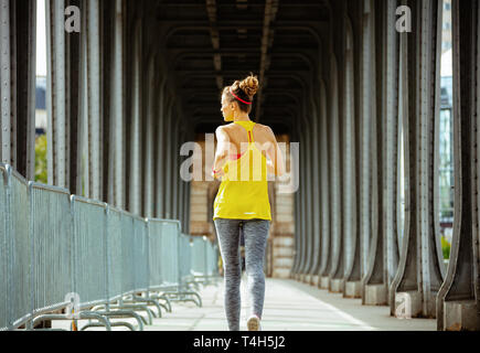 Vus de derrière, les sports actifs femme en vêtements de sport sur le Pont de Bir-Hakeim pont de Paris en cours d'exécution. Banque D'Images