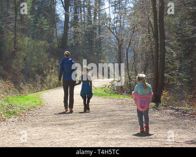Mère avec son fils et sa fille randonnées et s'amuser et être heureux ensemble et tenir la main. Voyage en famille dans une forêt au printemps. Banque D'Images