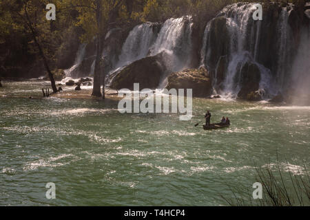 Cascade Kravice sur la rivière Trebizat River en Bosnie et Herzégovine, avril 2019. Bateau avec touristes sous la cascade. Banque D'Images