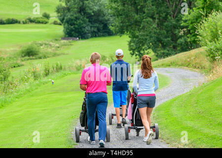 Golf de la famille sur le chemin de vol sur fairway Banque D'Images