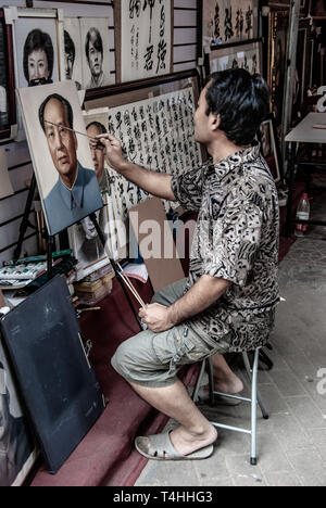 Artiste peint vintage portrait de Mao. L'homme chinois du village de Dafen au travail. Les résidents se spécialisent dans la copie et des répliques de célèbres peintures à l'huile. Banque D'Images