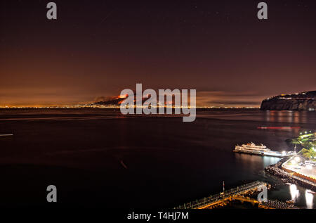 Le Vésuve Volcan de feu, de fumée, à la dérive sur Pompéi moderne. Une longue exposition photo nocturne à travers la baie de Sorrente à Naples. Banque D'Images