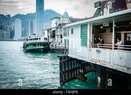 Pêcheur non identifié à la terrasse de ferry Tsim Sha Tsui's Star. Les pêcheurs chinois utilisent des poissons de pêche à la tige dans la mer au port de Victoria Banque D'Images