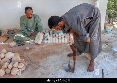 Louxor, Egypte - le 11 septembre 2018 : artisan égyptien le forage d'un trou cylindrique en pierre de granit pour faire un navire Banque D'Images