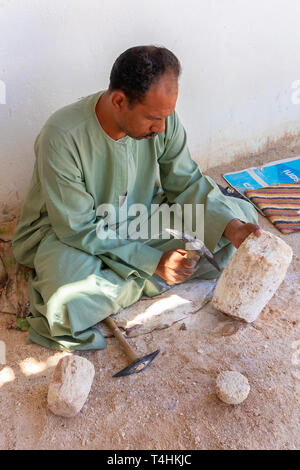 Louxor, Egypte - le 11 septembre 2018 : sculpteur sur pierre travaillant avec un marteau à la colonne d'albâtre Banque D'Images