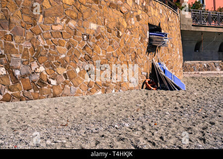 Dans la célèbre plage de Monterosso al Mare est quelqu'un sortir les chaises de plage pour l'été, Cinque Terre, ligurie, italie Banque D'Images