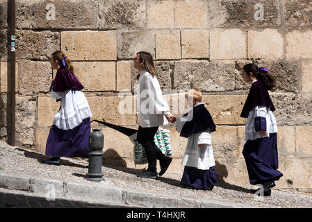 Une famille pénitents vu marcher à l'église avant de prendre part à la Sainte procession mardi à Grenade. La Semaine Sainte est l'un des plus importants de la tradition religieuse en Andalousie. Banque D'Images