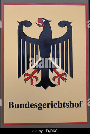 17 avril 2019, Bade-Wurtemberg, Karlsruhe : devant la Cour Suprême Fédérale (BGH) se bloque un signe avec aigle fédéral et le Tribunal fédéral de course. La huitième Sénat civile locataire négocie des licenciements pour des besoins personnels. Dans un cas de Berlin, un plus de 80 ans, est censé sortir après de nombreuses années parce qu'une jeune famille a acheté l'appartement. Dans le deuxième cas de Saxe-Anhalt, les propriétaires veulent entrer dans une partie de maison pour vivre plus près de la grand-mère a besoin de soins. Les locataires considèrent cette position déraisonnable pour des raisons de santé. Photo : Uli Deck/dpa Banque D'Images