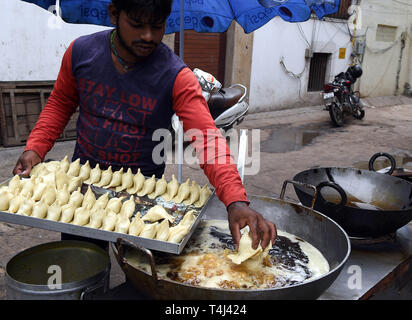 New Delhi, Inde. 17 avr, 2019. Un fournisseur d'aliments de rue Samosas fait à New Delhi, Inde, le 17 avril 2019. Samossas sont frites boulettes triangulaire rempli avec de la purée de pommes de terre, les lentilles, le sel et les épices qui sont généralement trouvés dans l'Inde. À un prix abordable, ils sont un snack populaire parmi les habitants et sont souvent apprécié avec la sauce chili ou curry. Credit : Zhang Naijie/Xinhua/Alamy Live News Banque D'Images