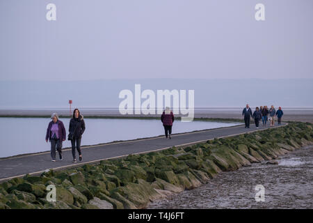 West Kirby, Wirral, UK. 17 avril, 2019. Les personnes bénéficiant d'une soirée à pied à l'ouest du lac marin dans le Wirral sur Kirby dans le nord-ouest de l'Angleterre le Mercredi, Avril 17, 2019 lorsque les températures sont à la hausse à venir du prochain week-end férié. Crédit : Christopher Middleton/Alamy Live News Banque D'Images