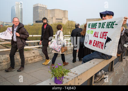 Londres, Royaume-Uni. 17 avril 2019. Les passants durant les heures de pointe d'œil sur une bannière affichée sur Waterloo Bridge par un militant du changement climatique de l'extinction au cours de la troisième journée de la rébellion des activités de rébellion. Credit : Mark Kerrison/Alamy Live News Banque D'Images