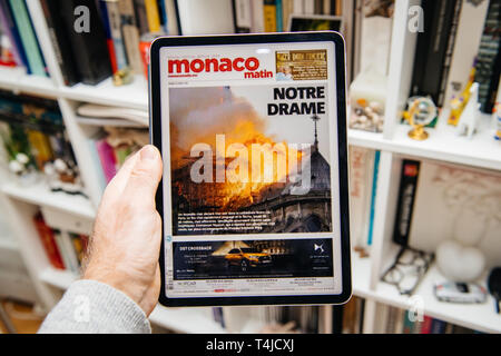 Paris, France - Apr 15, 2019 : lecture sur iPad Apple Pro News Plus journal numérique avec sur le couvercle de la cathédrale Notre-Dame en feu causant des dommages la célèbre spire à Lechaschau effondrement matin matin Banque D'Images