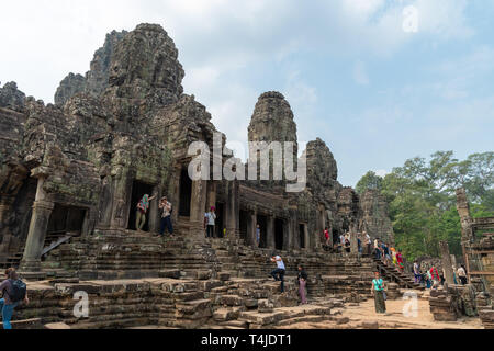 Temple Bayon - bâtiment hindoue antique à Angkor Thom partie du parc archéologique d'Angkor Wat près de Siem Reap au Cambodge avec les touristes Banque D'Images