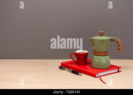 Cafetière italienne petite tasse et cahier rouge Banque D'Images