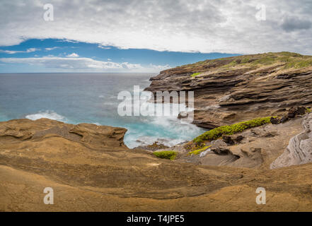 Les vagues de l'océan tourbillonnant autour de la roche de lave unique de formations le Lanai Lookout sur Oahu, Hawaii Banque D'Images