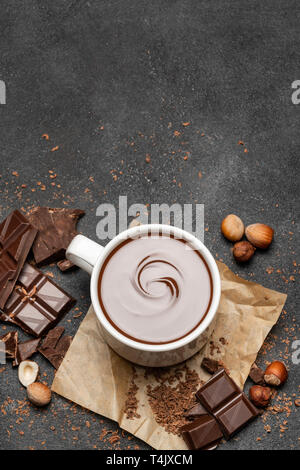 Tasse de chocolat chaud et des morceaux de chocolat noir sur fond de béton Banque D'Images