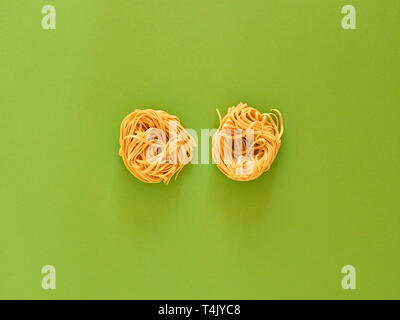 Pâtes et nouilles italiennes sur fond vert non cuites en studio en vue de dessus. Flatlay concept. Banque D'Images