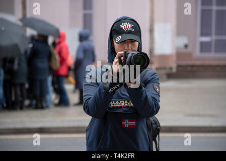 Avril 2019 , MOSCOU, RUSSIE. Photographe fille dans des vêtements sombres et une casquette de photographies sur les rues par temps humide Banque D'Images