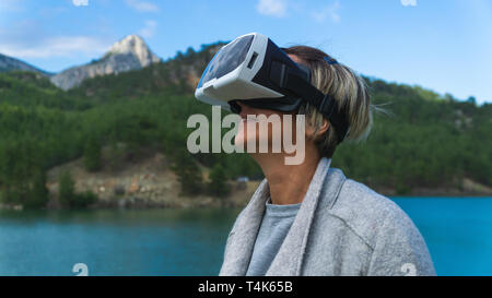 Femme dans la nature portant des lunettes de réalité augmentée.femelles adultes de s'amuser avec AR lunettes. L'avion. Lecture.la journée. Banque D'Images