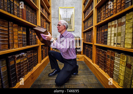 La cathédrale de Salisbury archiviste Colin Malcolm gère les livres reliés en cuir dans la cathédrale du 15e siècle, la bibliothèque où un projet en cours au catalogue, propre et en savoir plus sur la collection de livres rares est en cours. Banque D'Images