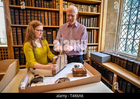 La cathédrale de Salisbury Colin bénévoles liens un ruban de protection Malcolm tandis qu'Emily archiviste Naish maintient stable dans la bibliothèque du 15e siècle de la cathédrale, où un projet en cours au catalogue, propre et en savoir plus sur la collection de livres rares est en cours. Banque D'Images